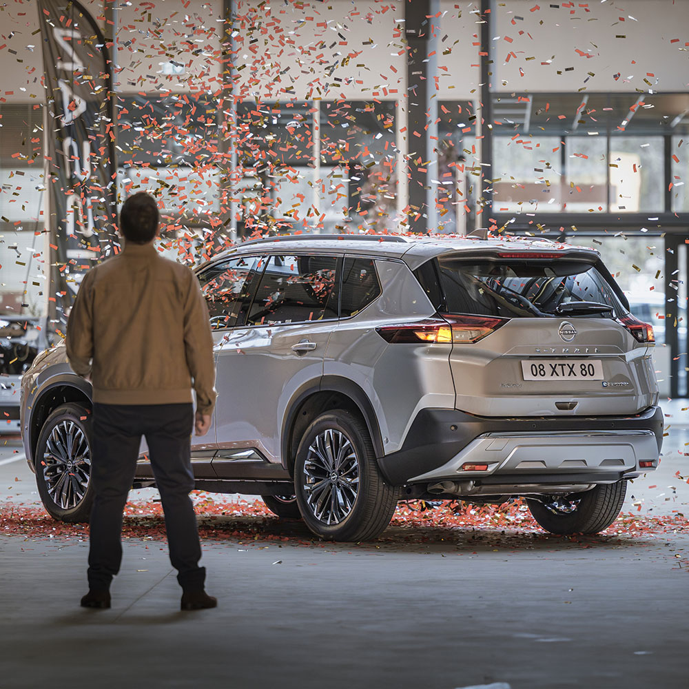 Homme devant Nissan X-Trail pour fêter les 2 ans de la garantie Nissan Privilège